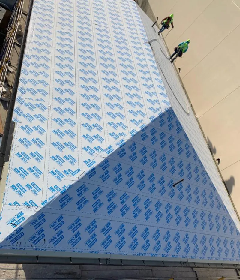 Professional roofers installing underlayment on a metal roof in Havre